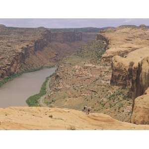 Mountain Bikers on Slickrock Trail Overlooking the Colorado River 