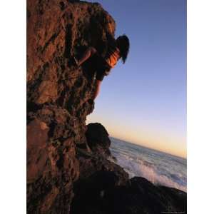  A Female Climber Scales a Rock Near the Pacific Ocean 